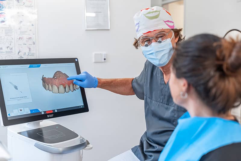 Herr Dr. Steuer zeigt Patientin 3D Röntgenbild ihrer Zähne