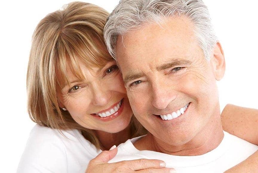 Lachendes Ehepaar mit Zahnimplantaten