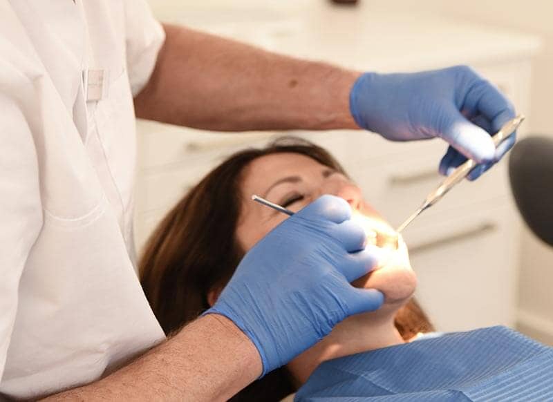 Dr. Steuer untersucht die Zähne einer Patientin im Rahmen der Vorsorge